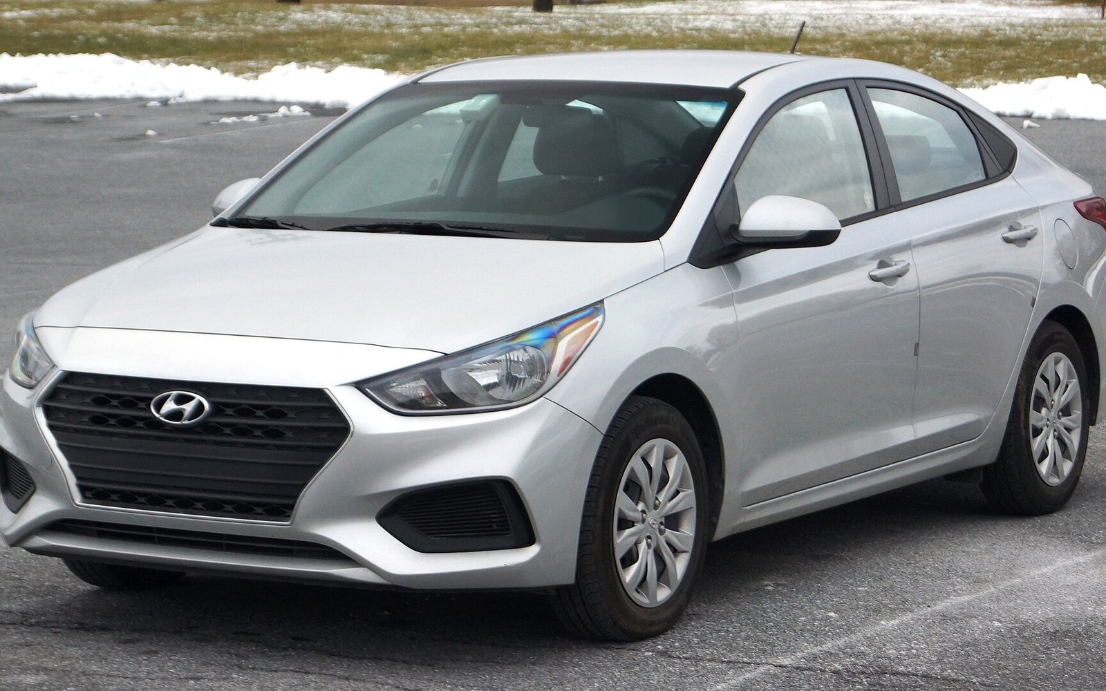 Hyundai Accent — Silver Hyundai Accent compact sedan rental car, front three-quarter view