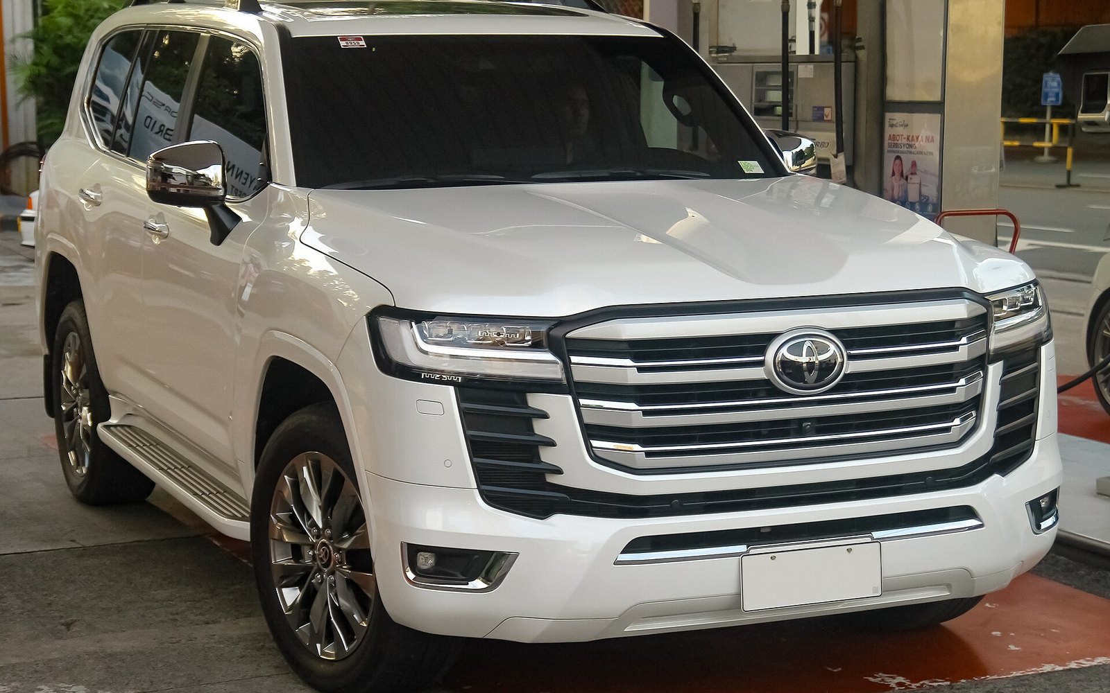 Toyota Land Cruiser — Pearl white Toyota Land Cruiser full-size SUV rental car, front three-quarter view