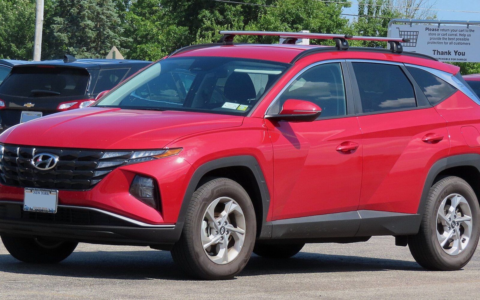 Hyundai Tucson — Red Hyundai Tucson crossover SUV rental car, front three-quarter view