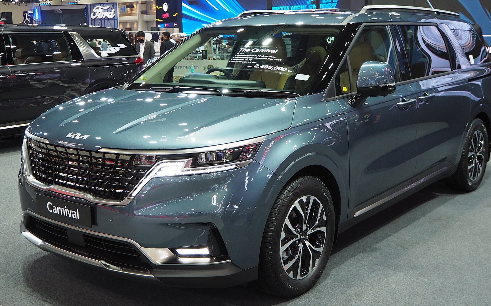 Kia Carnival — Green Kia Carnival seven-seater van rental car, front three-quarter view